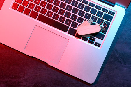 Modern laptop and wooden USB flash drive on black tableの写真素材