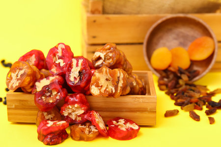 Box with delicious churchkhela and ingredients on yellow backgroundの写真素材