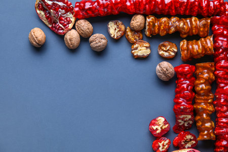 Frame made of delicious churchkhela, walnuts and pomegranate on blue backgroundの写真素材