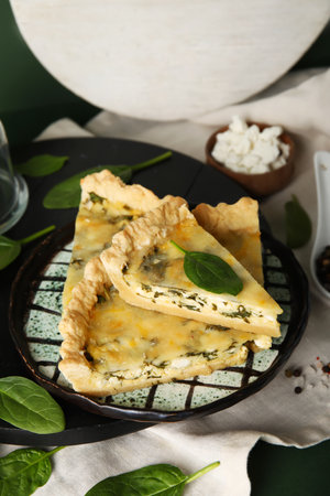 Plate with pieces of delicious quiche on green backgroundの写真素材