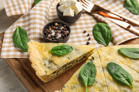 Board with pieces of delicious quiche, feta cheese and peppercorn, closeupの写真素材
