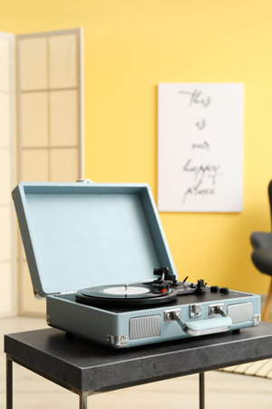 Record player with vinyl disk on table in roomの写真素材