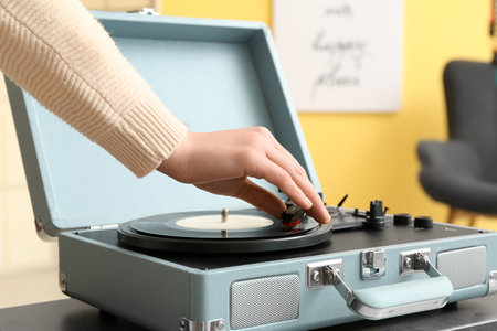 Woman using record player at home, closeupの写真素材