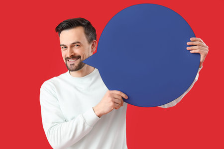 Handsome man with blank speech bubble on red background