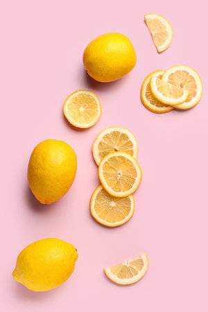 Composition with cut and whole fresh lemon on pink backgroundの写真素材