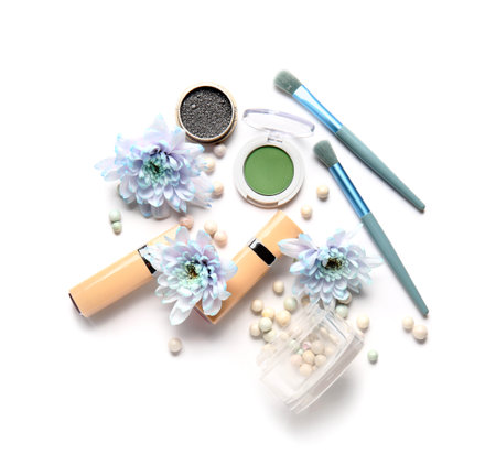 Decorative cosmetics with brushes and flowers on white backgroundの写真素材