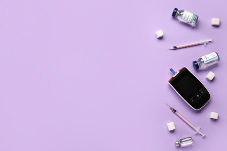 Glucometer with syringes, insulin and sugar on lilac background. Diabetes conceptの写真素材