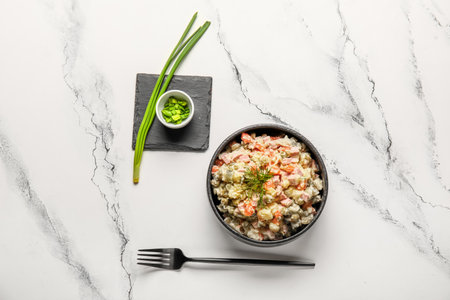 Bowl of tasty Olivier salad on white marble backgroundの写真素材