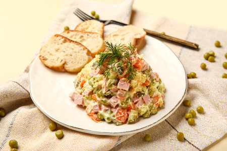 Plate of tasty Olivier salad on yellow backgroundの写真素材