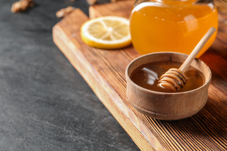 Bowl of sweet honey with dipper on dark backgroundの写真素材