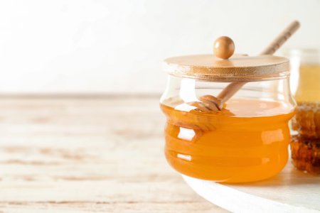 Jar of sweet honey with dipper on tableの写真素材