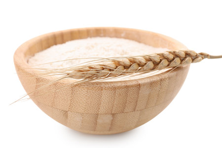 Wooden bowl with flour and wheat ear isolated on white backgroundの写真素材
