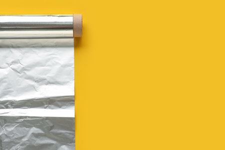 Roll of aluminum foil on yellow backgroundの写真素材