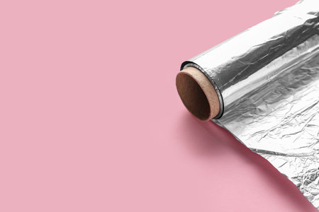 Aluminum foil roll on pink backgroundの写真素材
