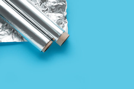 Aluminum foil rolls and sheet on color backgroundの写真素材