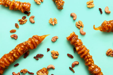 Composition with tasty churchkhela, nuts and raisin on color backgroundの写真素材