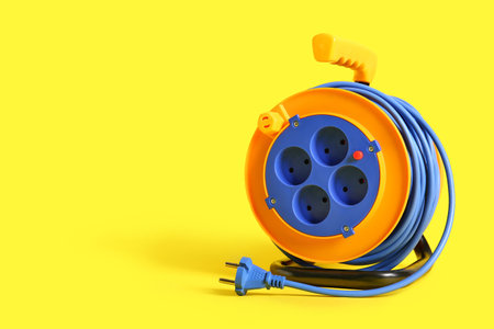 Extension electric cable reel on yellow backgroundの写真素材
