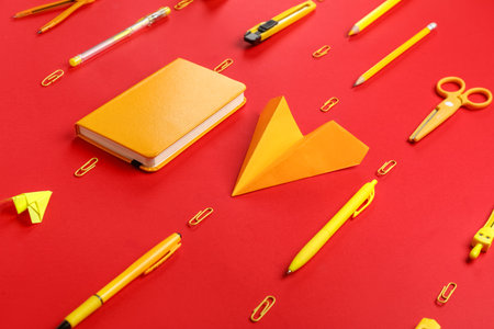 Composition with stationery supplies and paper planes on red backgroundの写真素材