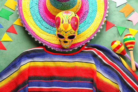 Mexican maracas with painted skull, sombrero hat, serape and flags on green backgroundの写真素材