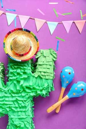 Mexican maracas with pinata, sombrero hat, paper flags and confetti on purple backgroundの写真素材