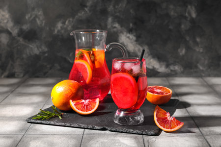 Glass and jug of tasty blood orange lemonade on dark backgroundの写真素材
