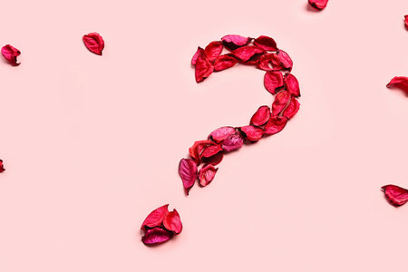 Question mark made of floral petals on pink background