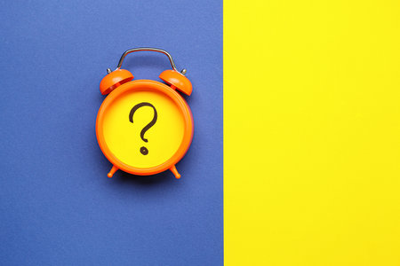 Alarm clock with question mark on color backgroundの写真素材