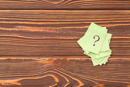 Papers with question marks on wooden backgroundの写真素材