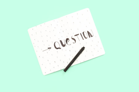 Notebook with word QUESTION and drawn marks on green backgroundの写真素材