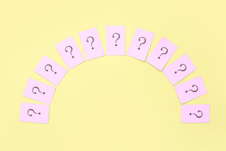 Papers with question marks on yellow backgroundの写真素材