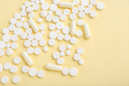 White pills on yellow background
