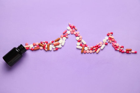 Bottle and cardiogram made of pills on lilac backgroundの写真素材