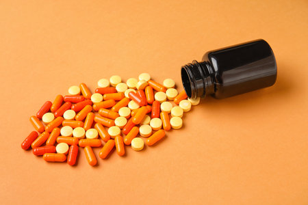 bottle with pills on orange backgroundの写真素材