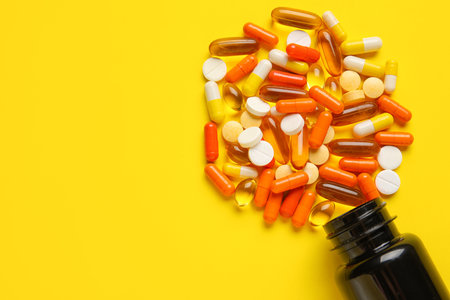 bottle with pills on yellow backgroundの写真素材