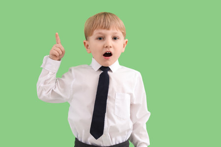 Funny little businessman pointing at something on green backgroundの写真素材