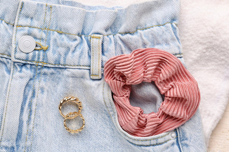 Silk scrunchy with jeans and rings on white fabric background, closeupの写真素材
