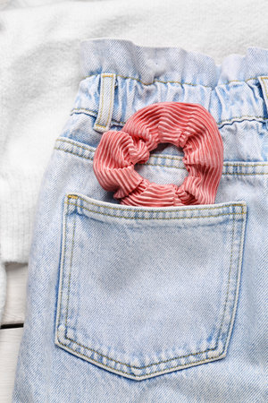 Silk scrunchy with jeans and sweater on white wooden background, closeupの写真素材