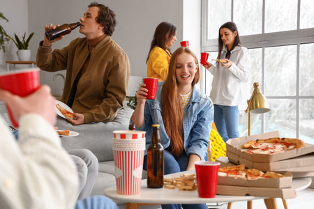 Group of friends with tasty pizza and drinks at homeの写真素材