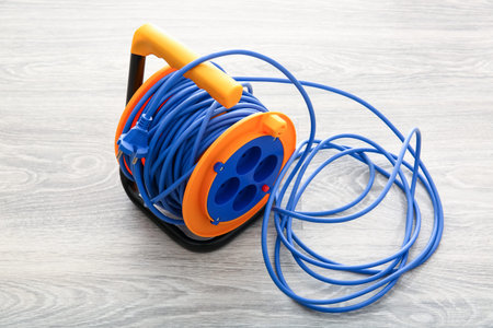 Extension electric cable reel on light wooden backgroundの写真素材