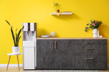 Interior of kitchen with modern water cooler near yellow wallの写真素材