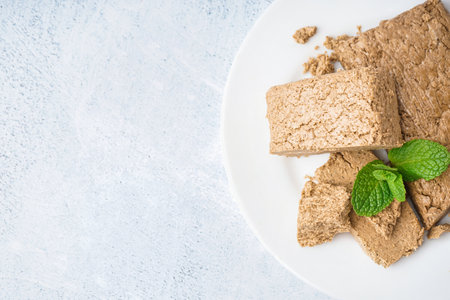 Plate with pieces of tasty halva on light backgroundの写真素材