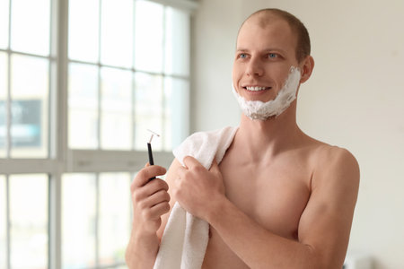 Young man shaving in the bathroomの写真素材