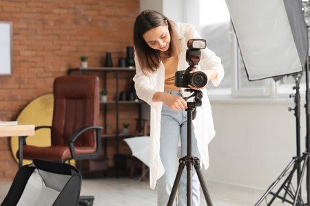 Female photographer with professional camera in studioの写真素材