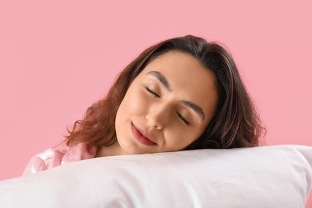 Young brunette woman with pillow on pink background, closeupの写真素材