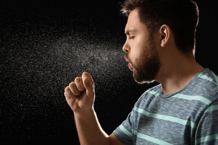 Coughing man on dark background. concept of epidemicの写真素材