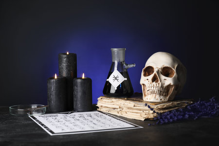 Potions, human skull and old book on alchemist's table