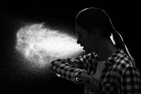 Coughing young woman on dark background. concept of epidemic