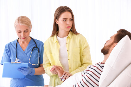Young woman visiting husband in hospitalの写真素材