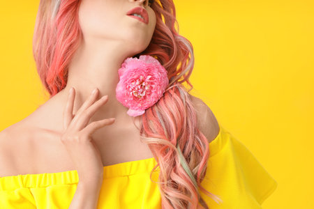 Beautiful young woman with unusual hair and flower on color backgroundの写真素材