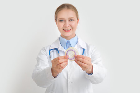 Female gynecologist with condom on white backgroundの写真素材